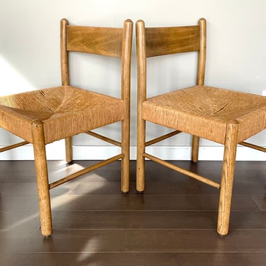 pair of vintage dining chairs with woven rush seat in the style of Charlotte Perriand. As-is condition