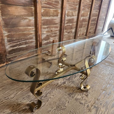 Glass Oval Coffee Table with Swirling Metal Base 52.75" x 16" x 22.75"