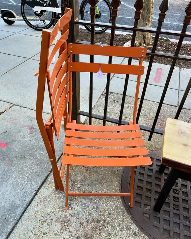 Two metal pumpkin spice folding chairs. 