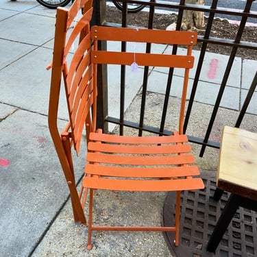 Two metal pumpkin spice folding chairs. 