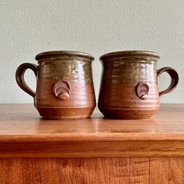 Pair of vintage studio pottery mugs / green and brown handmade coffee cups with shell motif signed by artist 