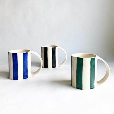 Large ceramic coffee mug with hand painted stripes in blue, red, green, black 