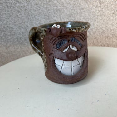 Vintage pottery mug ugly face 3D signed CC. Size 4” x 3.5” 