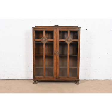 R. J. Horner Style Antique English Tudor Carved Oak Glass Front Double Bookcase, Circa 1900