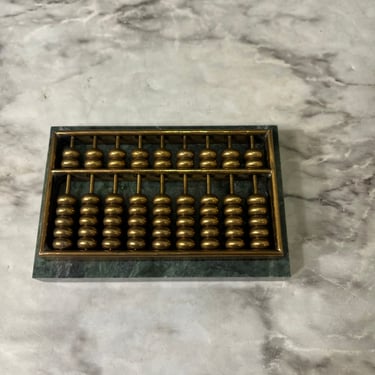 Small brass abacus on green marble