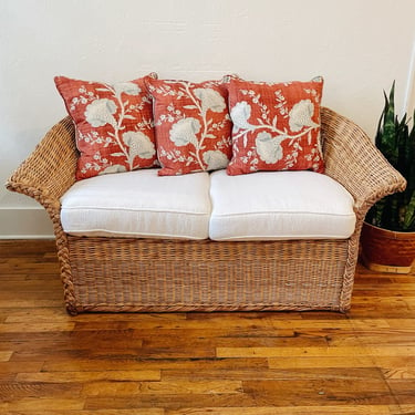 Braided Wicker Loveseat with white cushions + red pillows