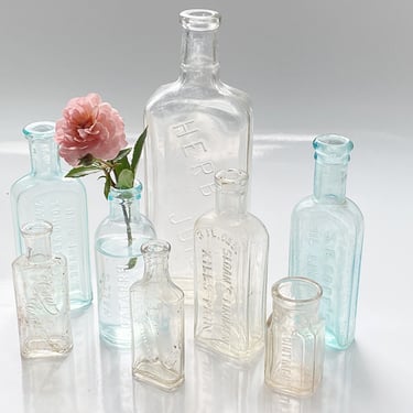 8 Vintage apothecary medicine bottle collection Embossed with pharmacy druggist quack cures, Decorative Aqua blue & clear glass bottle vases 