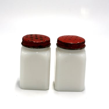 vintage milk glass salt and pepper shakers with red metal lids 