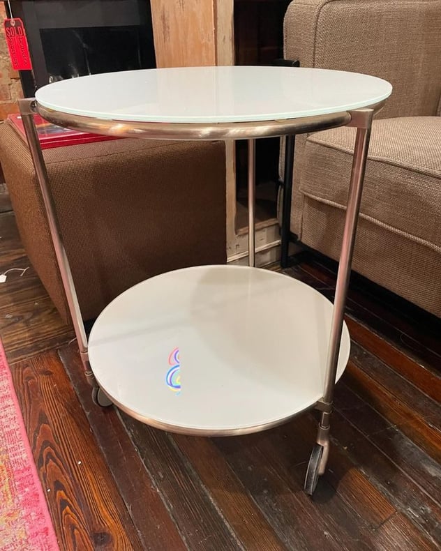 Sweet little white glass rolling table. 19.75x24”