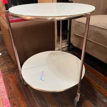 Sweet little white glass rolling table. 19.75x24”