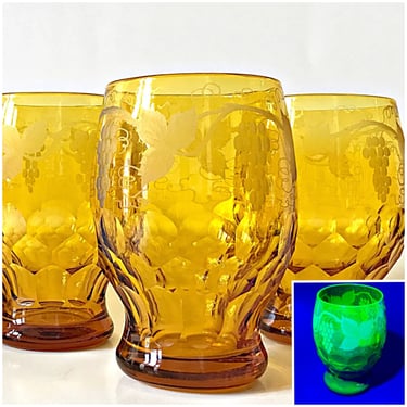 4 John Walsh drinking glasses. Wheel cut amber color uranium glass beer or water goblets. Large 20 oz tumblers w/ etched grape vine 