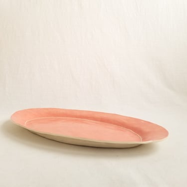 Oval ceramic serving platter in peachy pink 