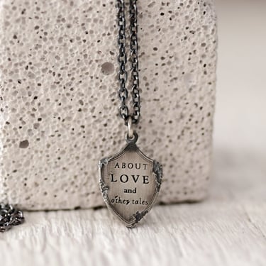 'About Love and Other Tales' Sterling Silver Shield Pendant Necklace