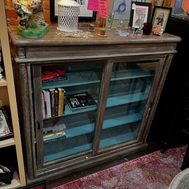 Glass front cabinet. 50” x 13.5” x 48.5” 