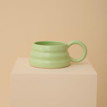 Green handmade ceramic mug with wiggly ripple shape 