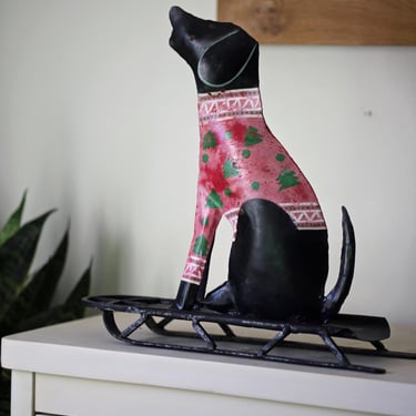 Vintage Metal Dog wearing Christmas sweater on sled 