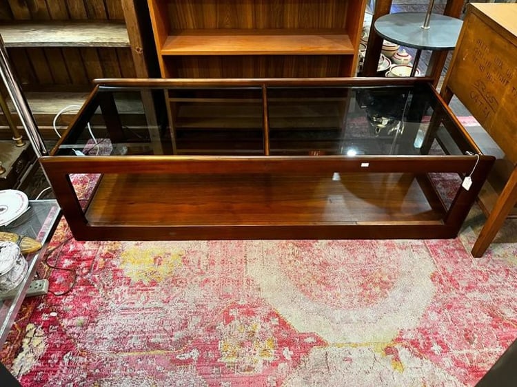 Smoked glass and dark wood mid century coffee table, 54” x 22” x 15” 