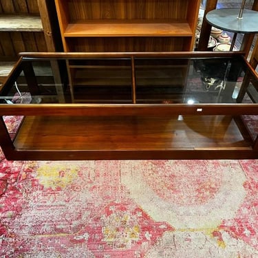 Smoked glass and dark wood mid century coffee table, 54” x 22” x 15” 