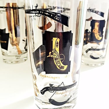 6 Vintage bar glasses for highball cocktails or beer. MCM black and gold western themed barware tumblers featuring antique guns & pistols. 