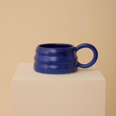 Blue handmade ceramic mug with wiggly ripple shape 