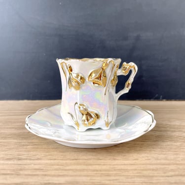 Gold iridescent demitasse cup and saucer with hand painted bell flowers 