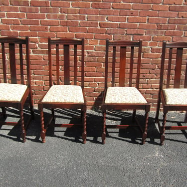 A Classic set of four English solid-oak dining chairs, with barley twist legs and drop-in seats. 